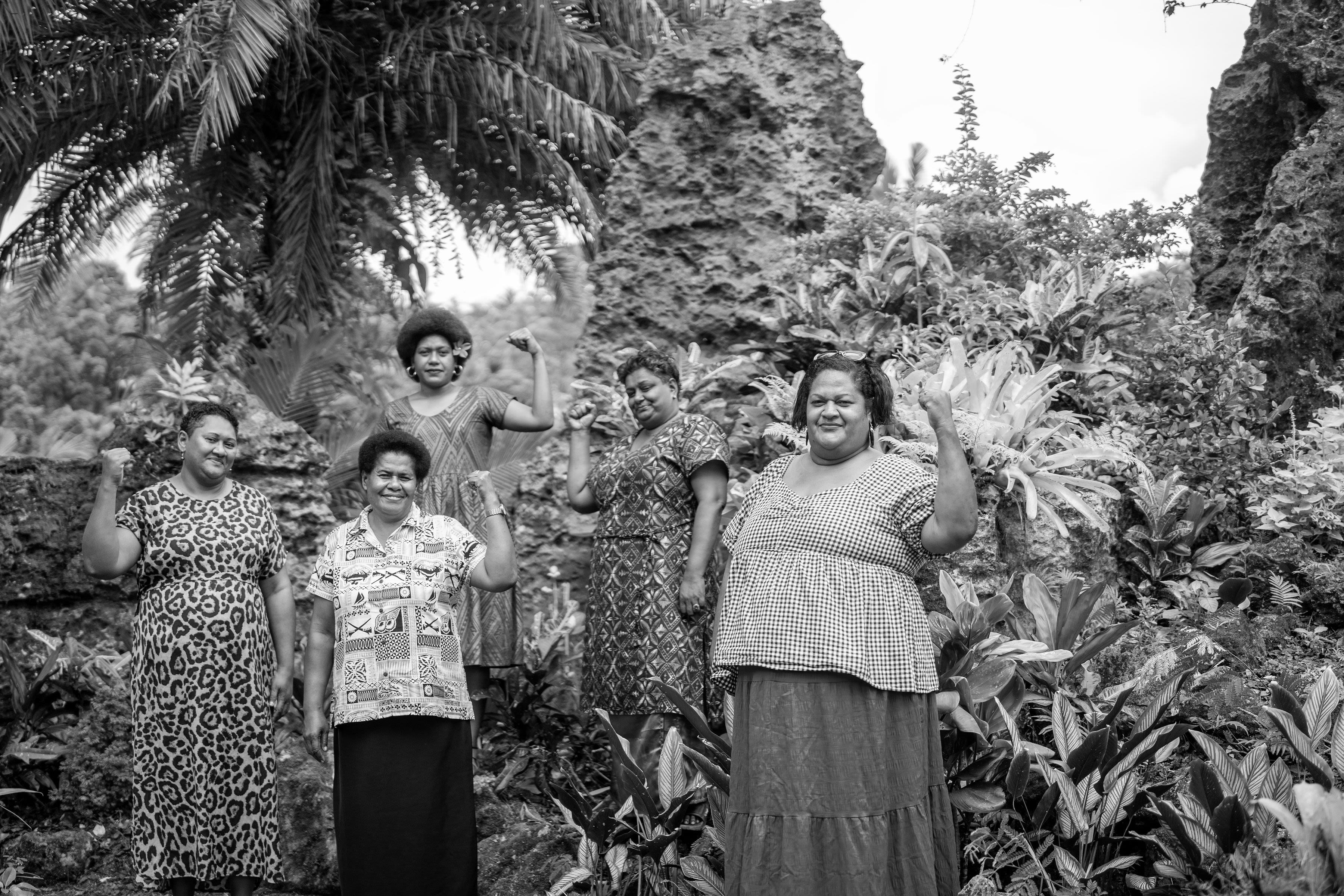 A group of Fijian women standing in front of plants