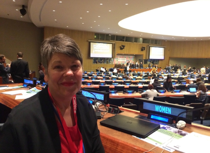 Jo Crawford at HLPF. There are chairs and desks around her and she is smiling