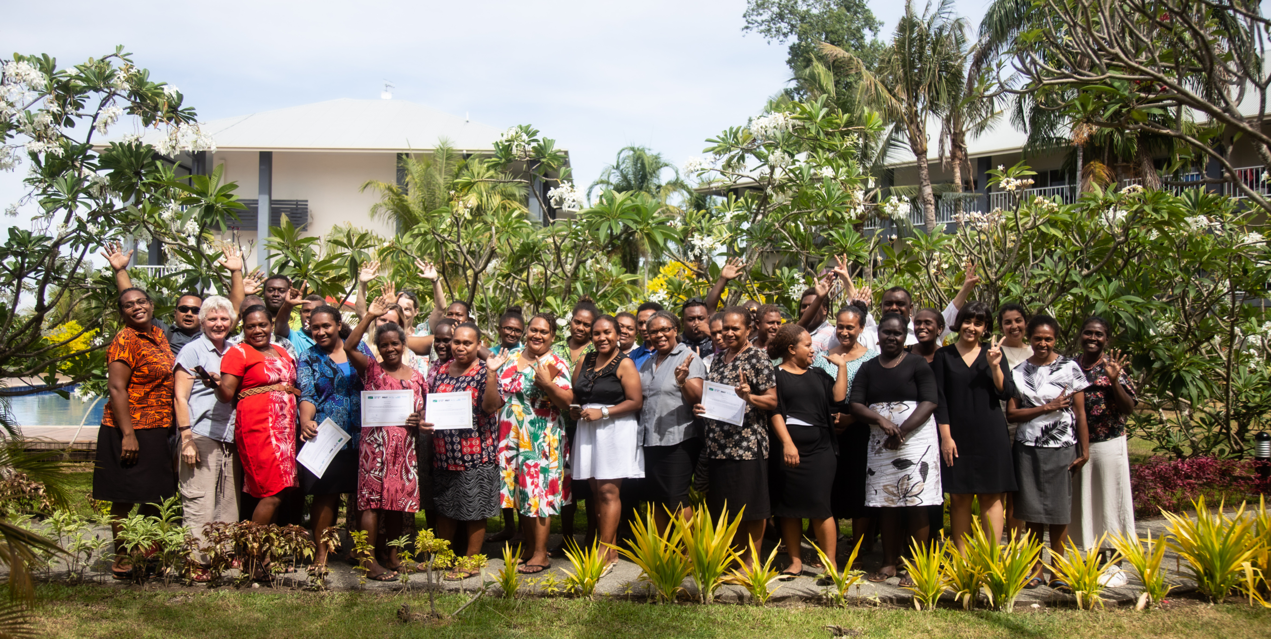 A large group of people in Solomon Islands holding certificates and smiling for a group photo, following gender data training.