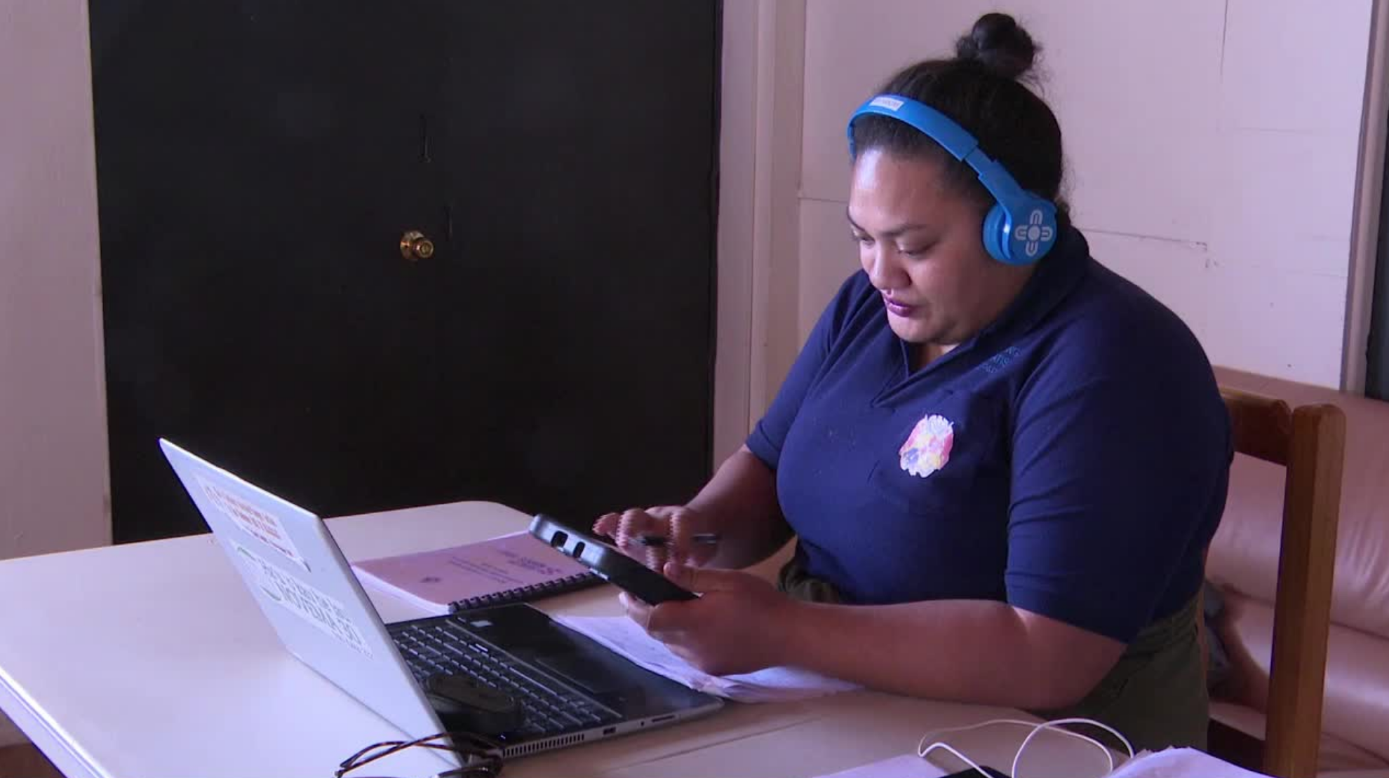 A woman sits in front of a laptop. She had a headset on and is using the Equality Insights Rapid survey in Tonga