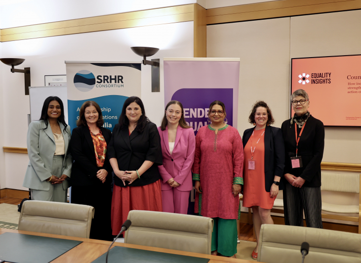Seven women standing in front of banners and screens that are promoting Equality Insights and APGPD