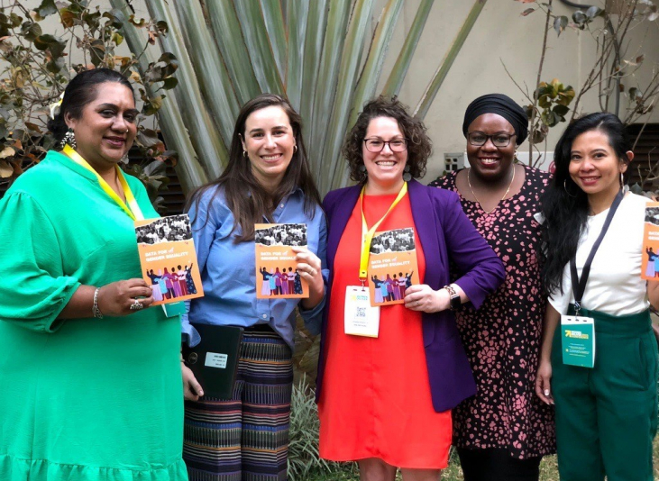 Five people in a row holding copies of the zine smiling