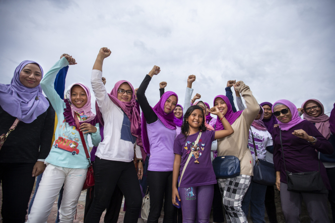 Group of woman stand with fists raised