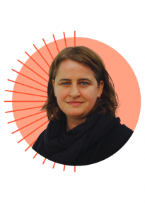 Portrait of a woman with short brown hair wearing a black scarf, in front of an orange circle with radial lines behind her.